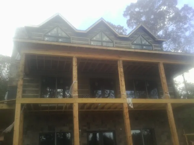 Dormers and porch framing on a large log home under construction in Cambridge